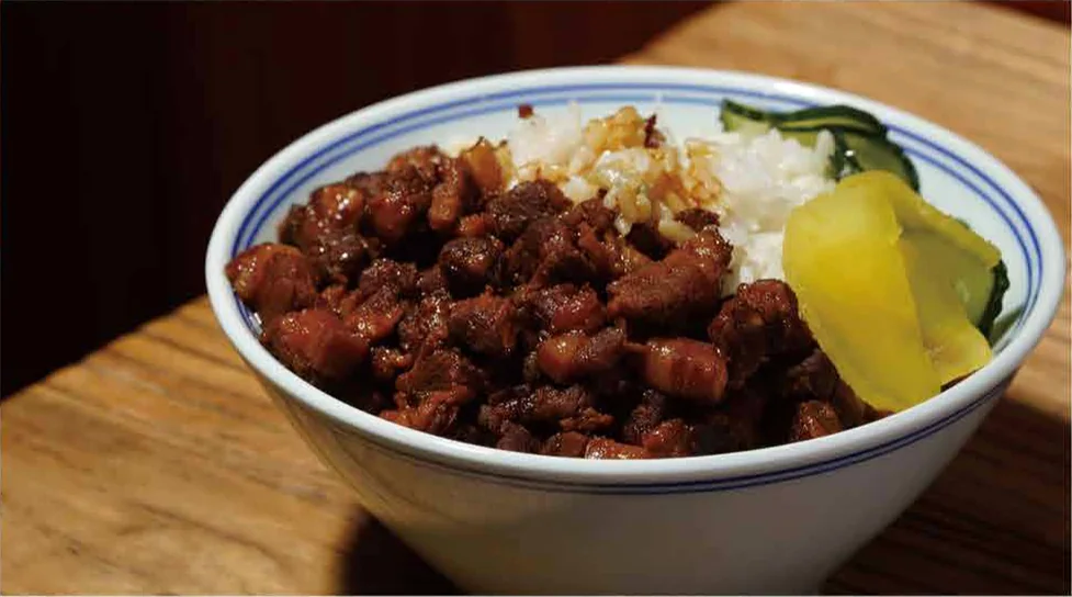 Grandma Lin's braised pork rice in a blue-and-white bowl, with pickled radish