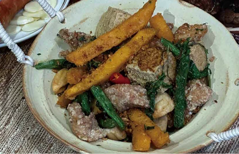 A plate of salt-and-pepper chicken with sweet potato fries, basil and fried bites
