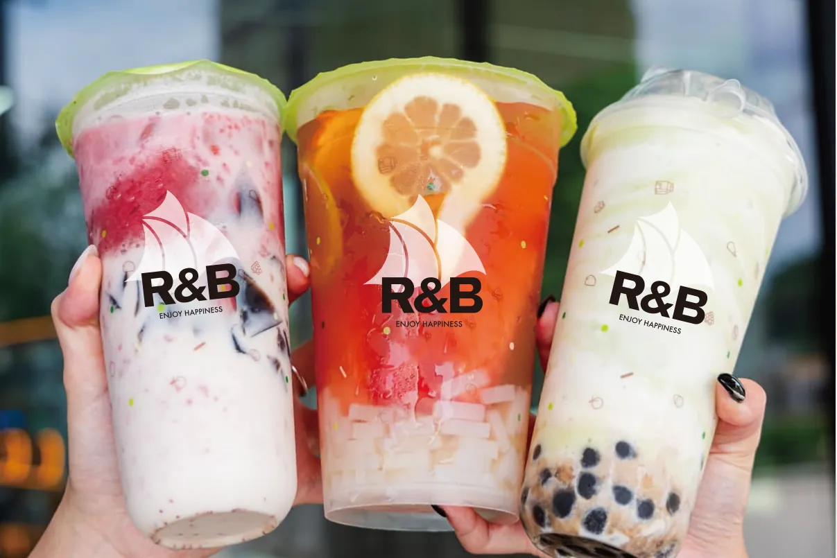 三杯 R&B 饮品：芋泥、橙片鲜果茶与黑糖波霸，杯身带 R&B 帆船标